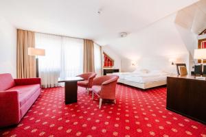 Habitación de hotel con cama y alfombra roja en Hotel Empfinger Hof, Sure Hotel Collection by Best Western, en Empfingen