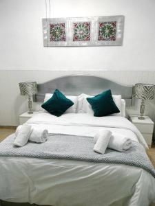 een slaapkamer met een groot wit bed met groene kussens bij Brily home in Vélez-Málaga