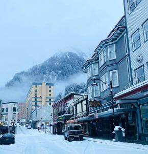 una strada innevata con edifici e una montagna di Alaskan Hotel and Bar a Juneau
