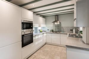 a white kitchen with white cabinets and appliances at Number 10, Whalley in Whalley