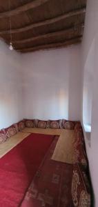 un sofá en una habitación con alfombra roja en Terre D'agafay, en Aït Mazou