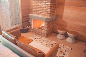 sala de estar con sofá y chimenea en Cabana Ouro do Vale - Nascer do Sol en Bento Gonçalves