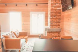 a living room with a couch and a brick wall at Cabana Ouro do Vale - Nascer do Sol in Bento Gonçalves