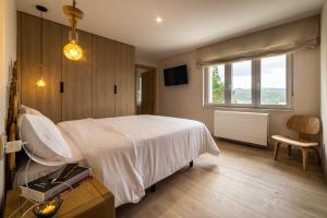 a bedroom with a white bed and a window at Villa Rucheira -Costa da Morte- in A Coruña