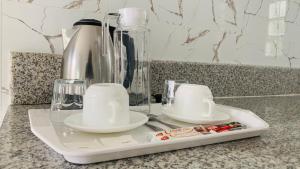 a tray with two cups and a blender on a counter at Sena Gladyz Suites in Panabo