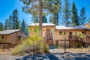 a house in the woods with a tree at Huntington Lake Condo 115 in Lakeshore