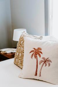 a pillow with palm trees on it sitting on a bed at Federal Hotel Mudgee in Mudgee