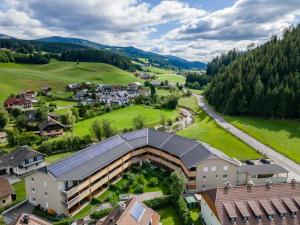 an aerial view of a building with a green field and trees at Lungau Residence Top 0-6 in Tamsweg