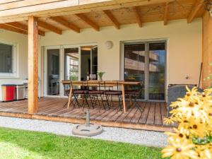 eine Holzterrasse mit einem Tisch und Stühlen darauf in der Unterkunft Lungau Residence Top 0-6 in Tamsweg