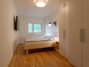 um quarto com uma cama e uma janela em Lungau Residence Top 0-6 em Tamsweg
