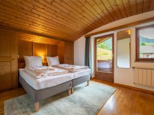 ein Schlafzimmer mit einem Bett und einem großen Fenster in der Unterkunft Chalet Alpbach 532 in Alpbach
