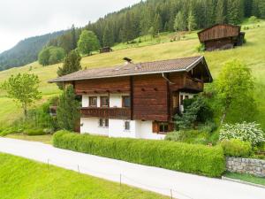 ein Holzhaus auf einem Hügel mit einer Straße in der Unterkunft Chalet Alpbach 532 in Alpbach