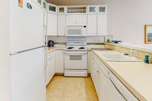a kitchen with white cabinets and white appliances at Salt Pond -- 23 Topsail Village in Bethany Beach