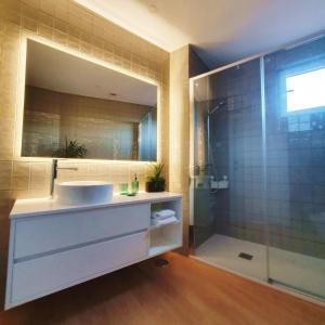 a bathroom with a sink and a shower at O 21 da Vila in Seia