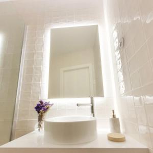 a white bathroom with a sink and a mirror at O 21 da Vila in Seia +18 photos