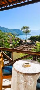 a table and chairs on a balcony with a view of the ocean at Pousada Aquarela do Mar in Abraão