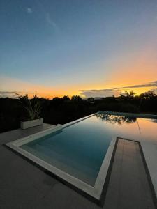 a swimming pool with a sunset in the background at Torcaza Casa de Campo in Quimbaya