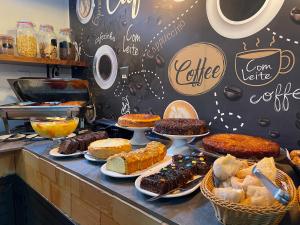 um balcão de padaria com diferentes tipos de bolos e pastelarias em Hotel Conchas em Penha