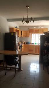 uma cozinha com uma mesa e um frigorífico em Quiet Cabin in San Gabriel Mixtepec 