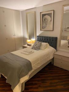 a bedroom with a large bed and a mirror at Habitaciones en San Isidro in Lima