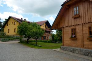 a couple of buildings with a tree in the yard at Tourist Farm Ob izviru Krupe in Semič