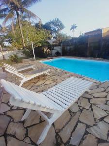 a white lounge chair next to a swimming pool at Pousada Vila do Sonho in Paraty