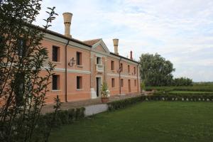 a large building with two chimneys on top of a yard at Agriturismo Villa Anconetta in Loreo