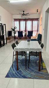 D Naurah Meritus Guesthouse في بيراي: غرفة معيشة مع طاولة وكراسي