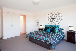a bedroom with a bed with blue pillows at The Dunes 17 38 Marine Drive fabulous unit with pool tennis court in Fingal Bay