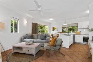 a living room with a couch and a table at 4 Munna Cove in Noosaville