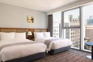 Giường trong phòng chung tại Stanford Hotel Myeongdong