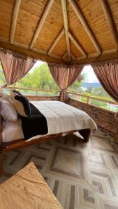 a bed in a room with a wooden ceiling at Chalet Amadeus Guatavita in Guatavita