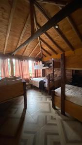 a large room with two beds and a wooden ceiling at Chalet Amadeus Guatavita in Guatavita