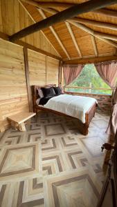 1 dormitorio con 1 cama en una habitación de madera en Chalet Amadeus Guatavita en Guatavita