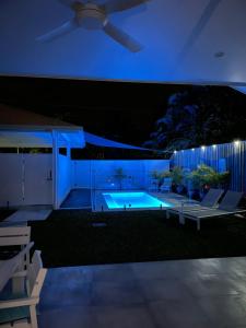 a swimming pool at night with a ceiling fan at WhiteSands in Port Douglas