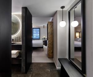 a hotel room with a bathroom with two beds at Hotel AKA NoMad in New York