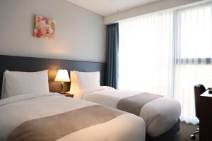 Giường trong phòng chung tại Stanford Hotel Myeongdong