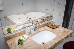 a bathroom with two sinks and a bath tub at Hotel SPA Paraíso in Cruzeiro do Sul