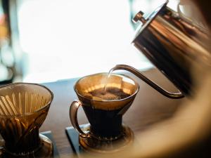 a cup of coffee sitting next to a tea kettle at Hotel Pacific Kanazawa in Kanazawa