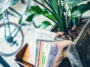 a pile of books sitting on a table next to a plant at Hotel Pacific Kanazawa in Kanazawa