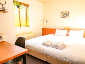 a bedroom with a bed with two towels on it at Hotel Pacific Kanazawa in Kanazawa