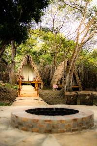 a group of huts in a forest with a fountain at Z'Alpes Camping e Restaurante in Tianguá
