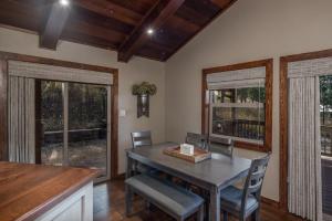 a dining room with a table and chairs and windows at Moon Mountain Escape in Ruidoso +17 photos
