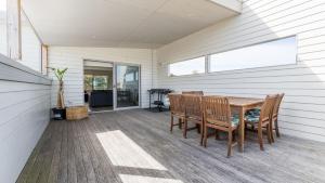 a dining room with a table and chairs on a porch at South Coast Retreat in Inverloch