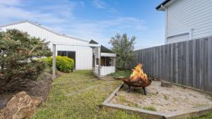a fire pit in a yard next to a house at South Coast Retreat in Inverloch