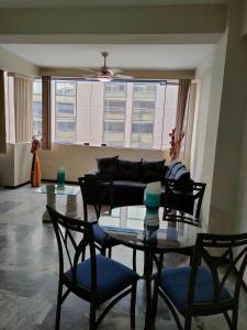 sala de estar con mesa, sillas y sofá en OCEANIk SUITES & HOTEL en Guayaquil