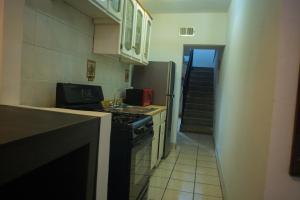 una cocina con fogones y fregadero y una escalera en Casa Genova, casa amplia y comoda, terraza privada, en Ciudad Juárez