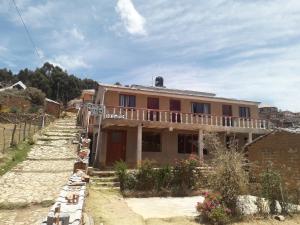 a house on a dirt road next to a building at Inka Wasi in Isla de Sol