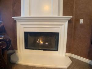 a white fireplace in a living room with flames at AirBB Rooms in Mansion in Riverside