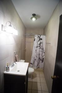 La salle de bains est pourvue d'un lavabo, de toilettes et d'une douche. dans l'établissement Casa Genova, casa amplia y comoda, terraza privada, à Ciudad Juárez